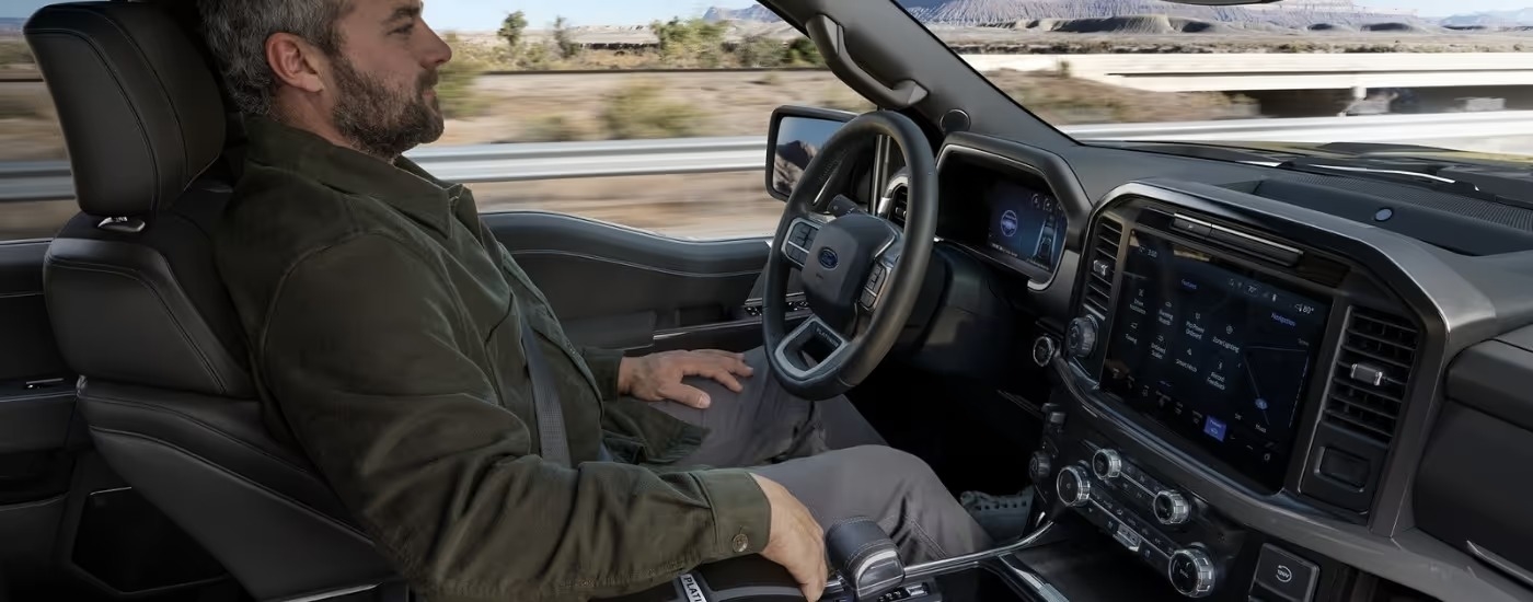 A man using BlueCruise while sitting in the driver's seat of a 2025 Ford F-150.