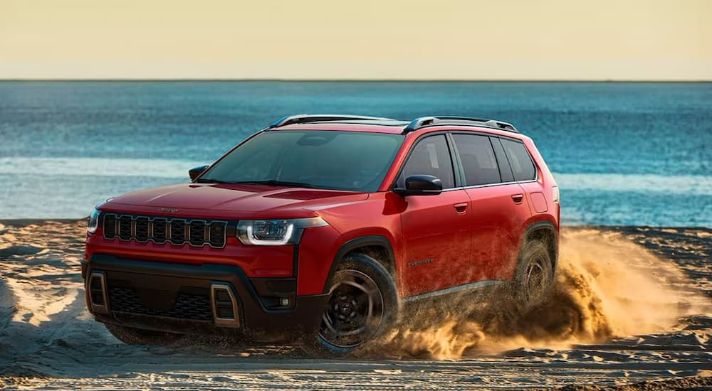 Red 2026 Jeep Cherokee driving off-road.