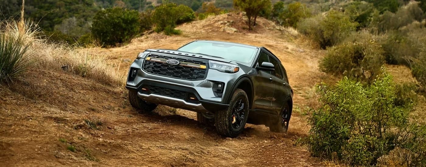 A black 2026 Ford Explorer Tremor off-roading up a dirt hill