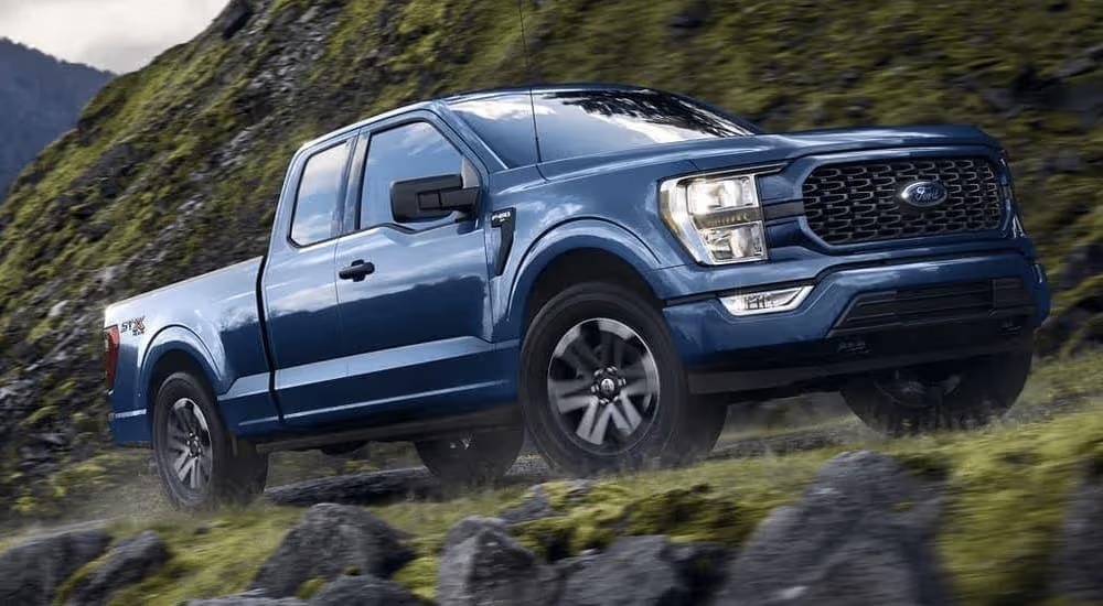 A blue 2023 Ford F-150 STX is shown from the side.