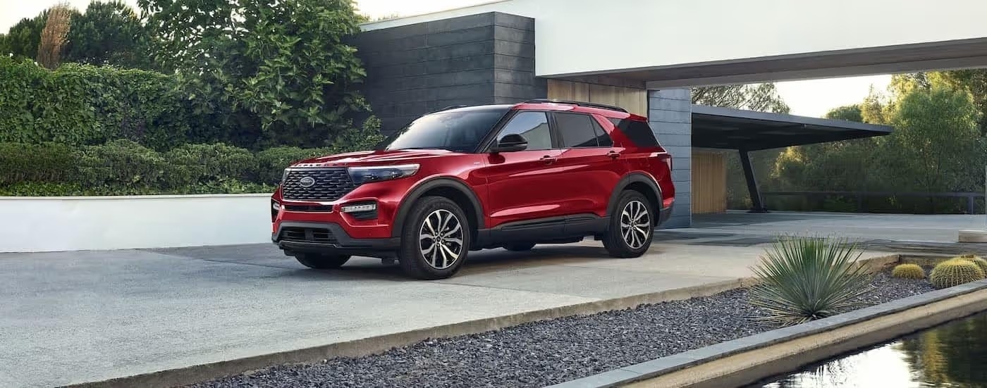 A red 2024 Ford Explorer for sale is shown parked on a driveway.