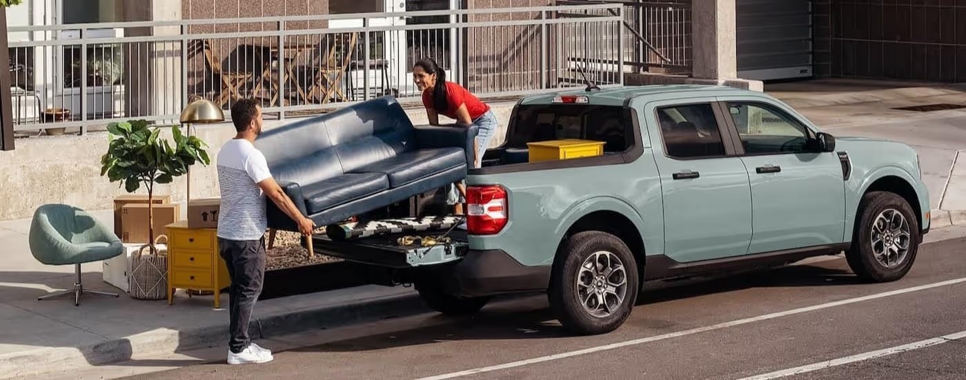 A blue 2024 Ford Maverick is shown parked near a city curb.