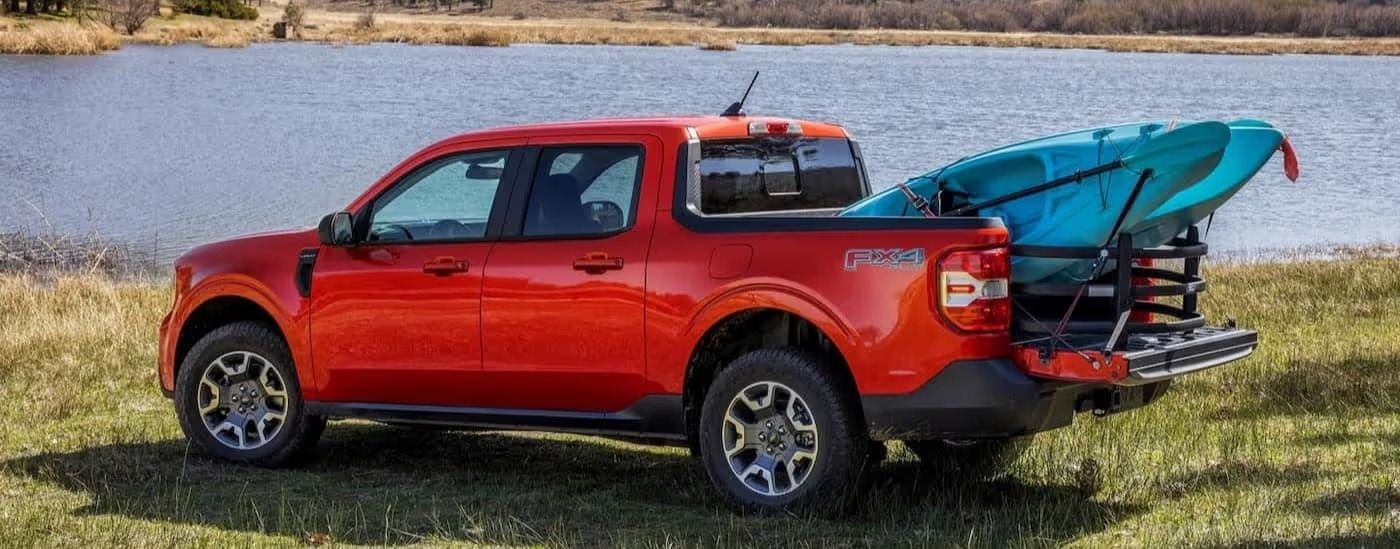 A red 2024 Ford Maverick Fx4 is shown parked near a lake.