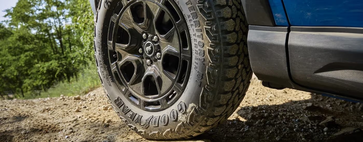 Close-up of a tire with rim on a blue 2025 Ford Bronco Sport