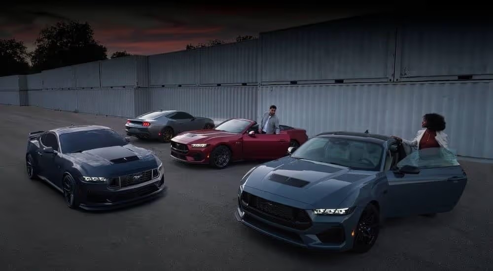 The 2024 Ford Mustang lineup is shown near shipping containers.