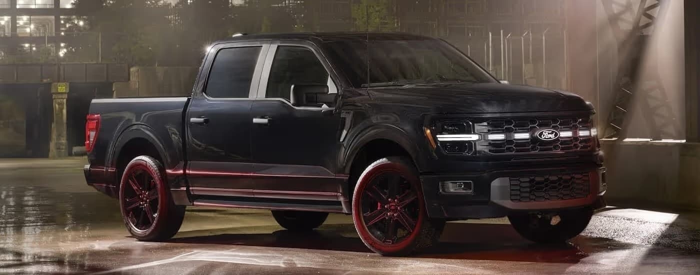 A black 2025 Ford F-150 STX LOBO parked on a wet surface.