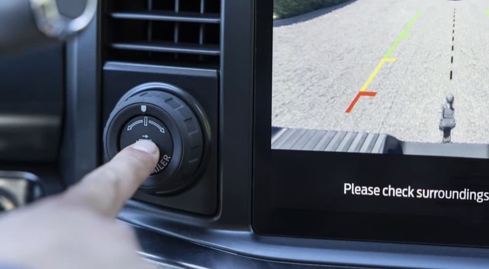 Person pressing a button in a 2023 Ford F-250