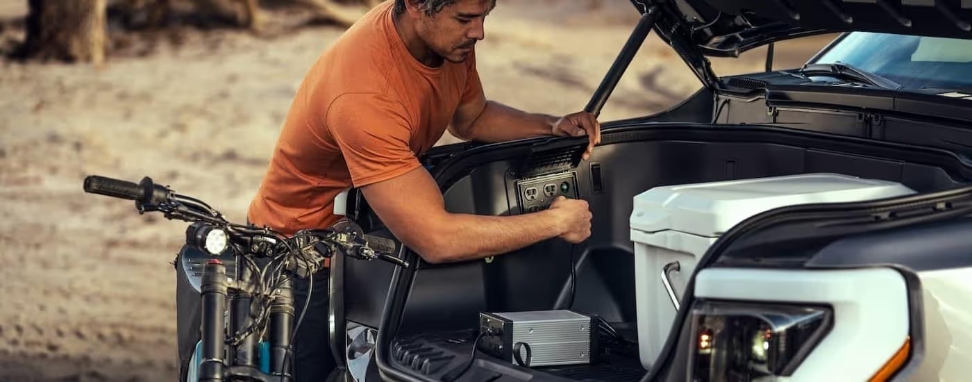 A person is shown utilizing an electrical outlet on a 2024 Ford F-150 Lightning.