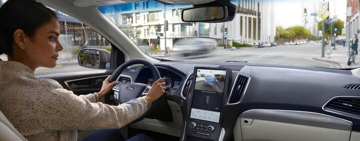 The black and white interior and dash of a 2024 Ford Edge is shown.