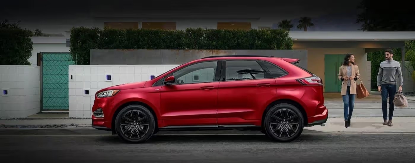 A red 2024 Ford Edge is shown parked near two people walking.