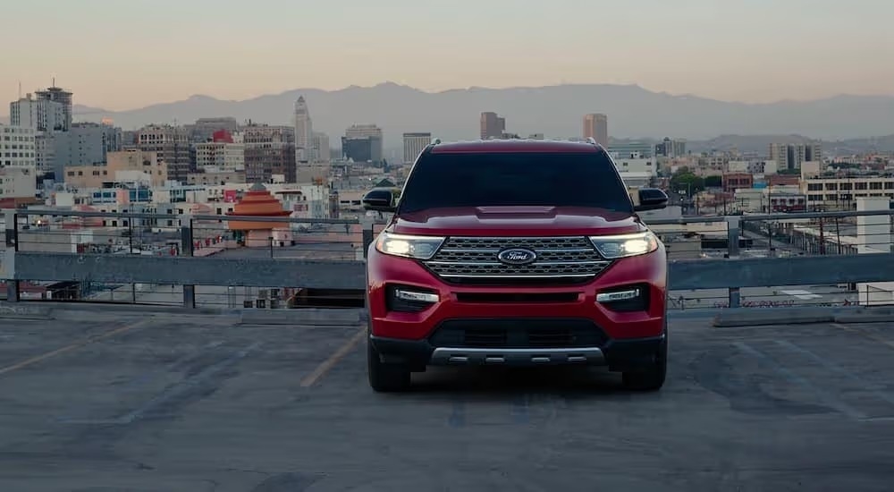 A red 2023 Ford Explorer Limited Hybrid is shown on a rooftop parking garage.