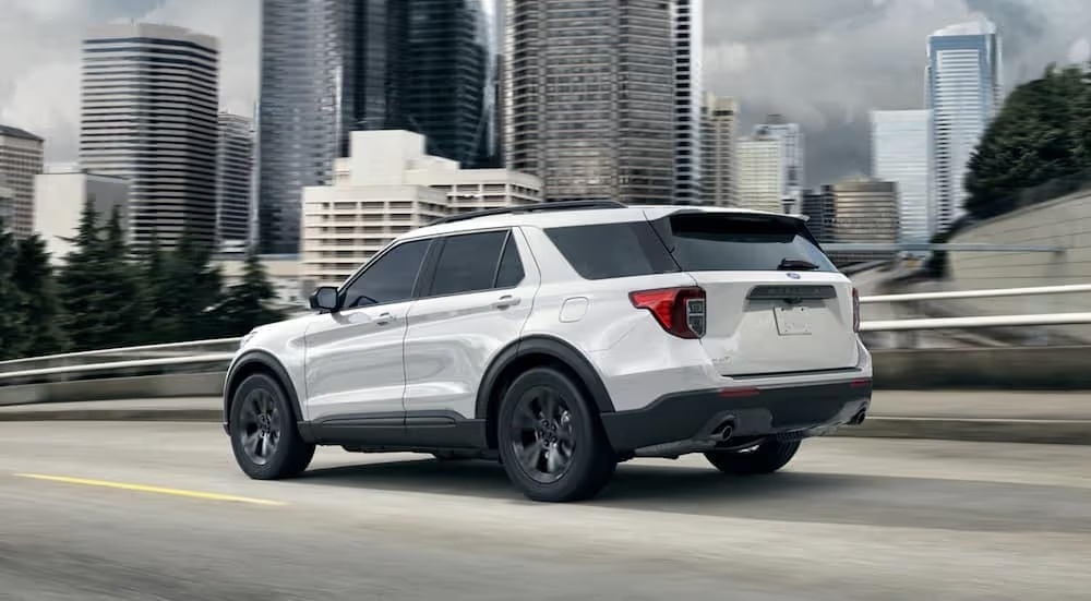 A white 2021 Ford Explorer is shown on a city street.