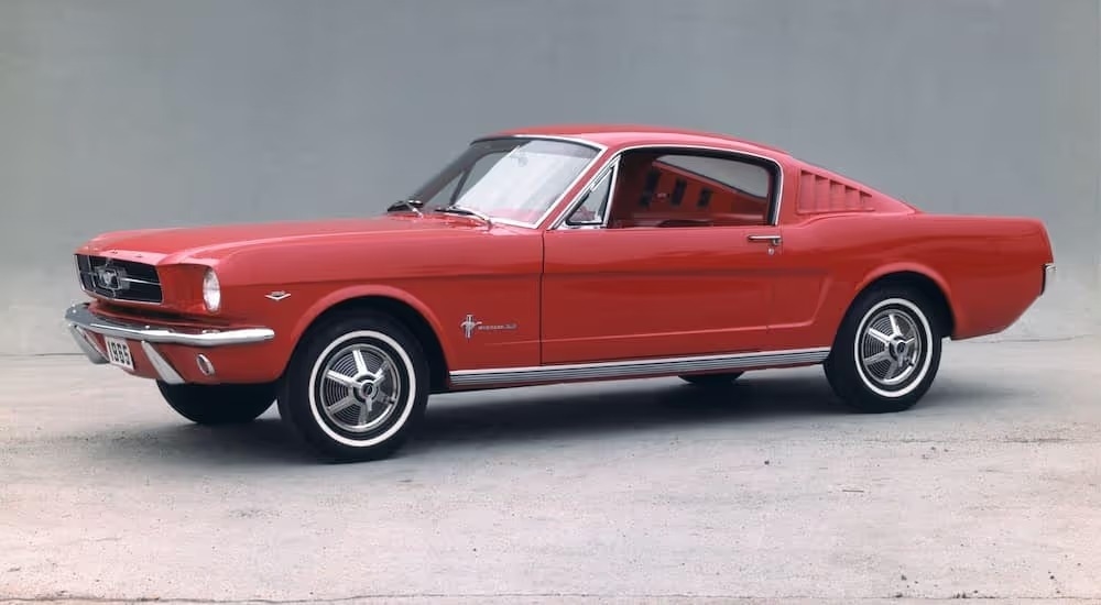 A red 1965 Ford Mustang is shown angled left.