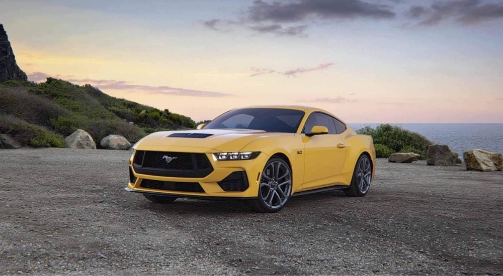 Yellow 2024 Ford Mustang GT parked on gravel