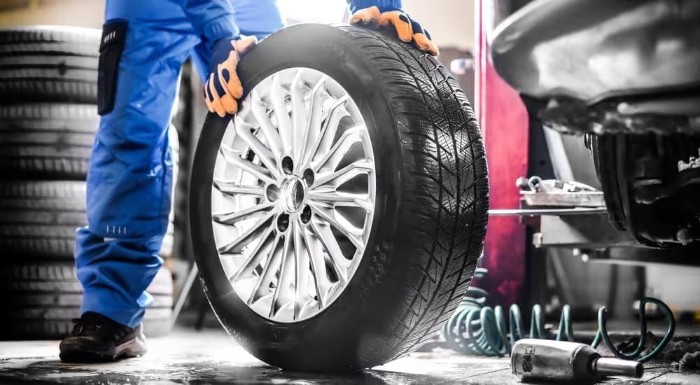 A mechanic is shown rolling a tire.