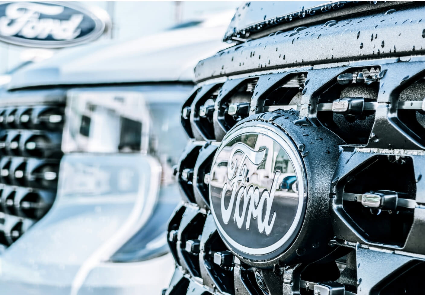 Close-up view of a Ford F-150 Raptor front grille highlighting the Ford emblem outside of a dealership.