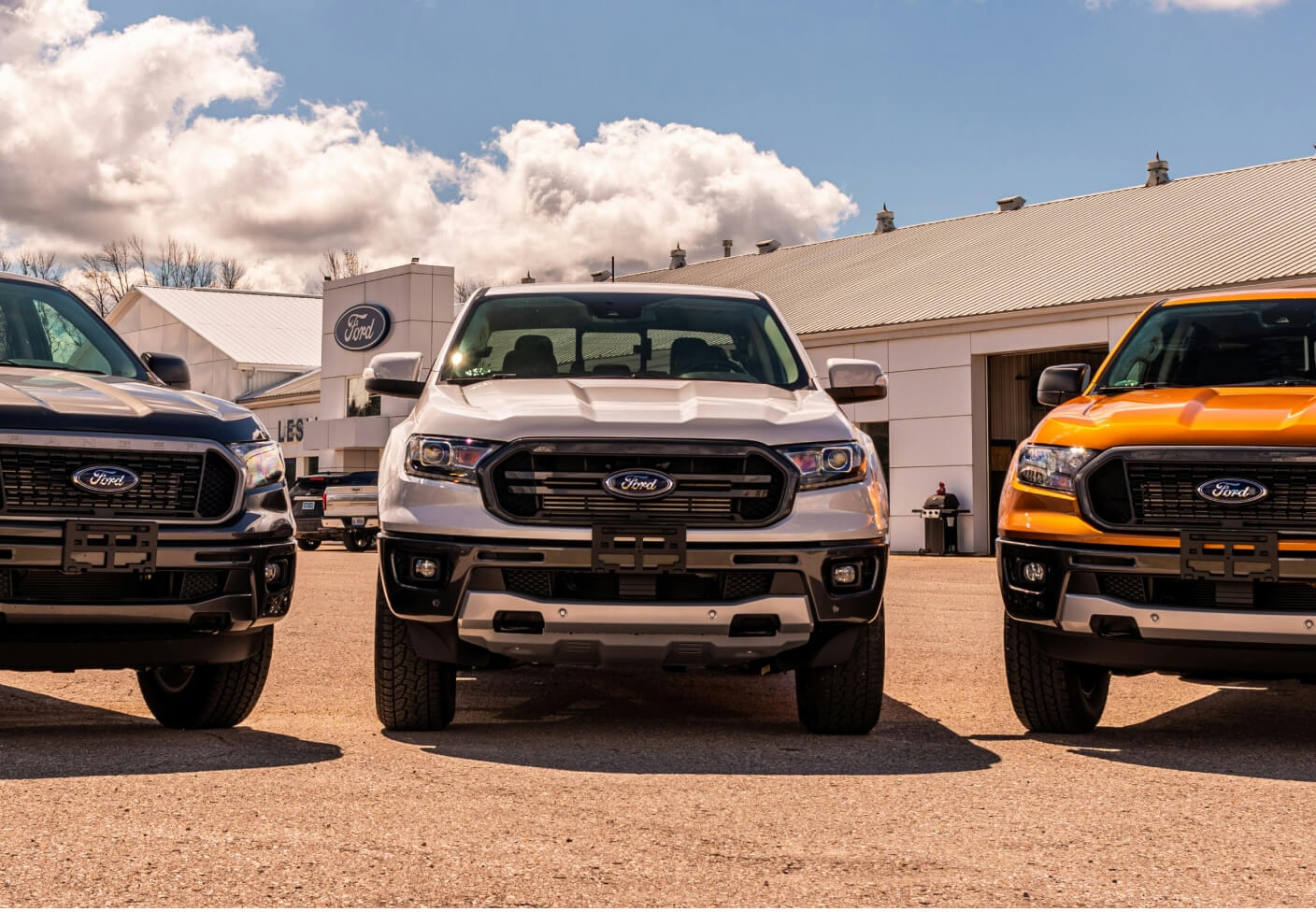 Front view of three 2020 Ford Ranger Trucks lined up side by side  outside of a dealership.