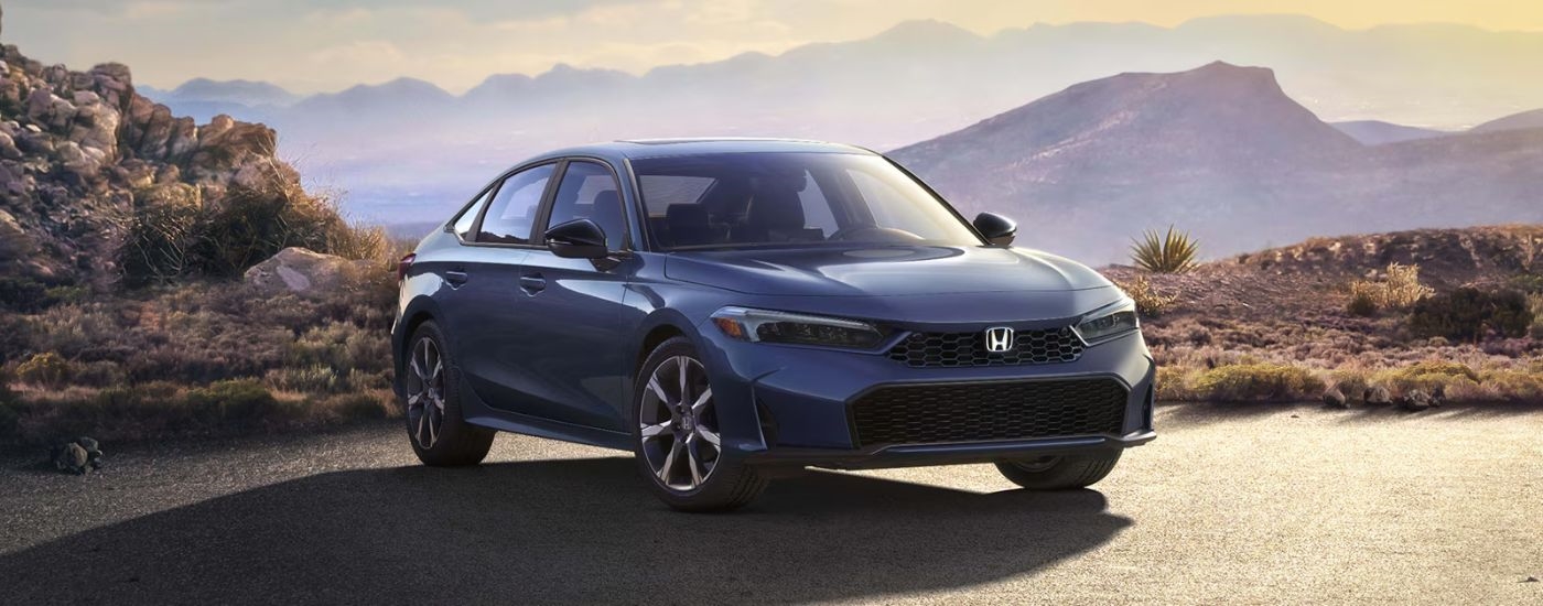 A blue 2026 Honda Civic shown parked with mountains behind.