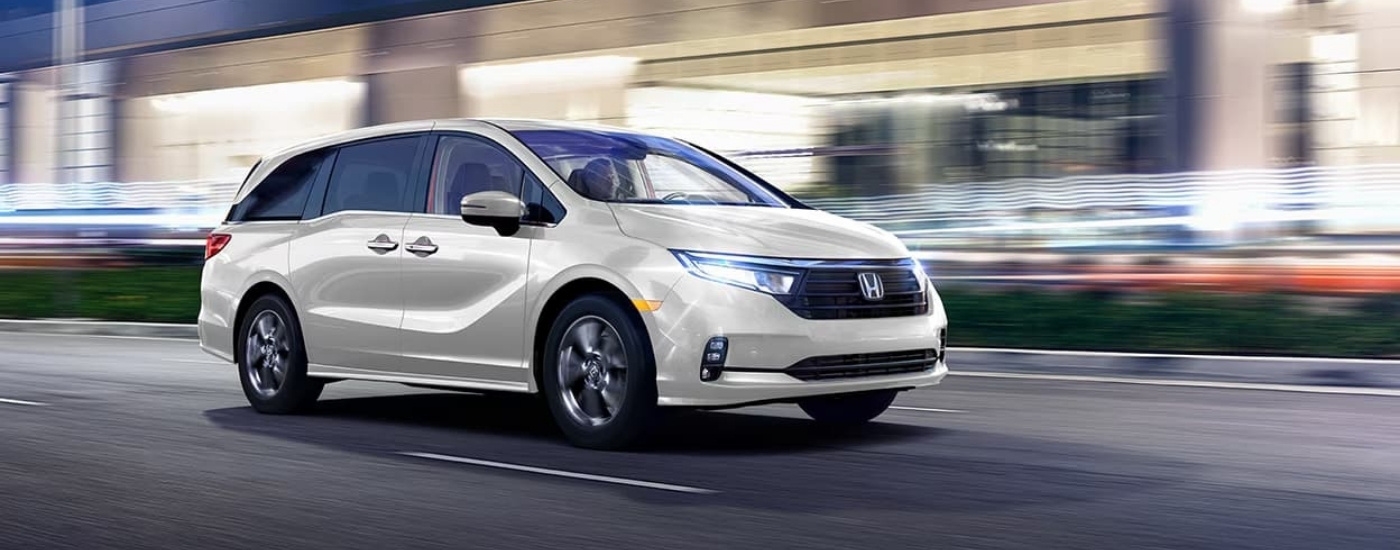 A white 2023 Honda Odyssey shown driving at night.