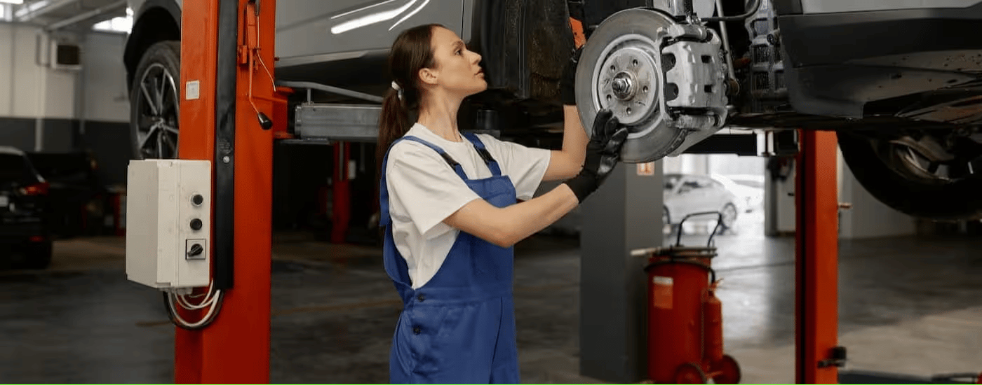 A mechanic is shown working at a Ford service center.