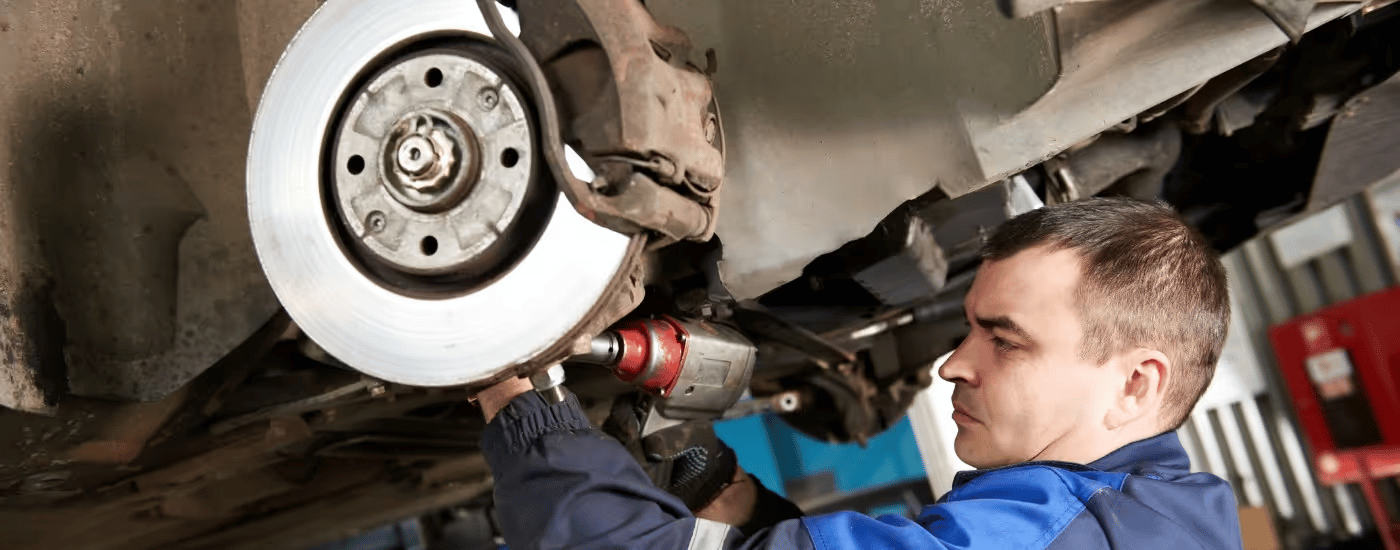 A mechanic working on a vehicle at a Ford service center near Smyrna.