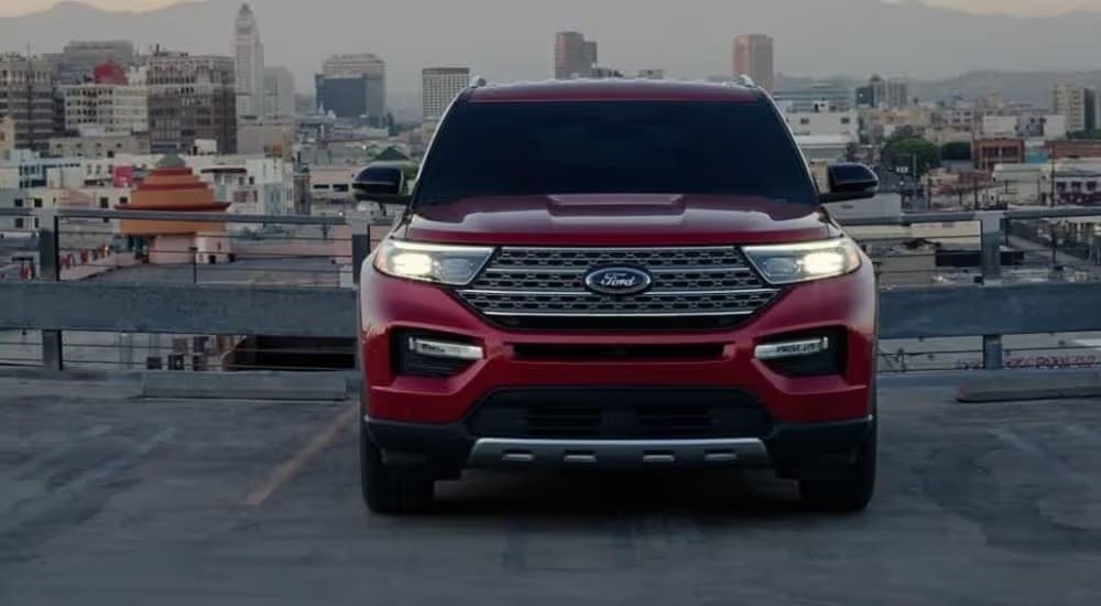 A red 2024 Ford Explorer Limited is shown parked near a city.