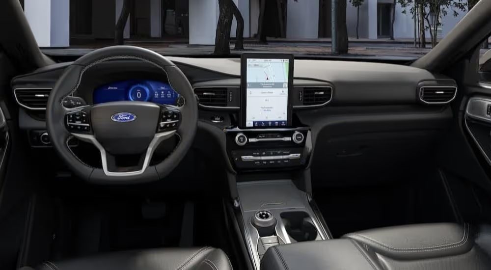 Infotainment display and steering wheel on a black interior of a 2024 Ford Explorer.