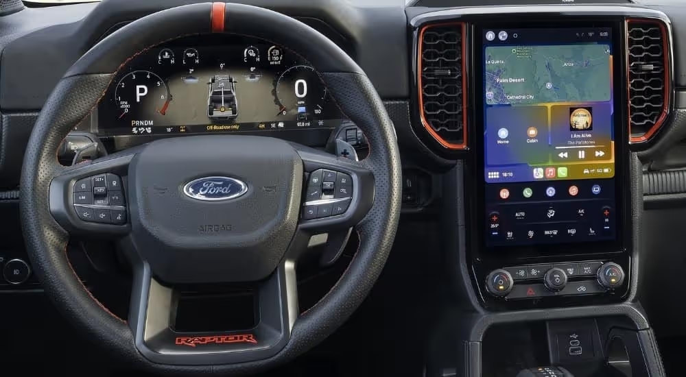 Close-up of the steering wheel and infotainment screen in a 2025 Ford Ranger Raptor.