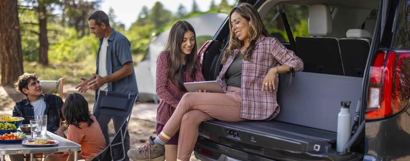 Five people gathered near the rear of a 2025 Ford Expedition.