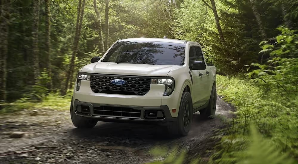 A white 2025 Ford Maverick is shown off-roading.