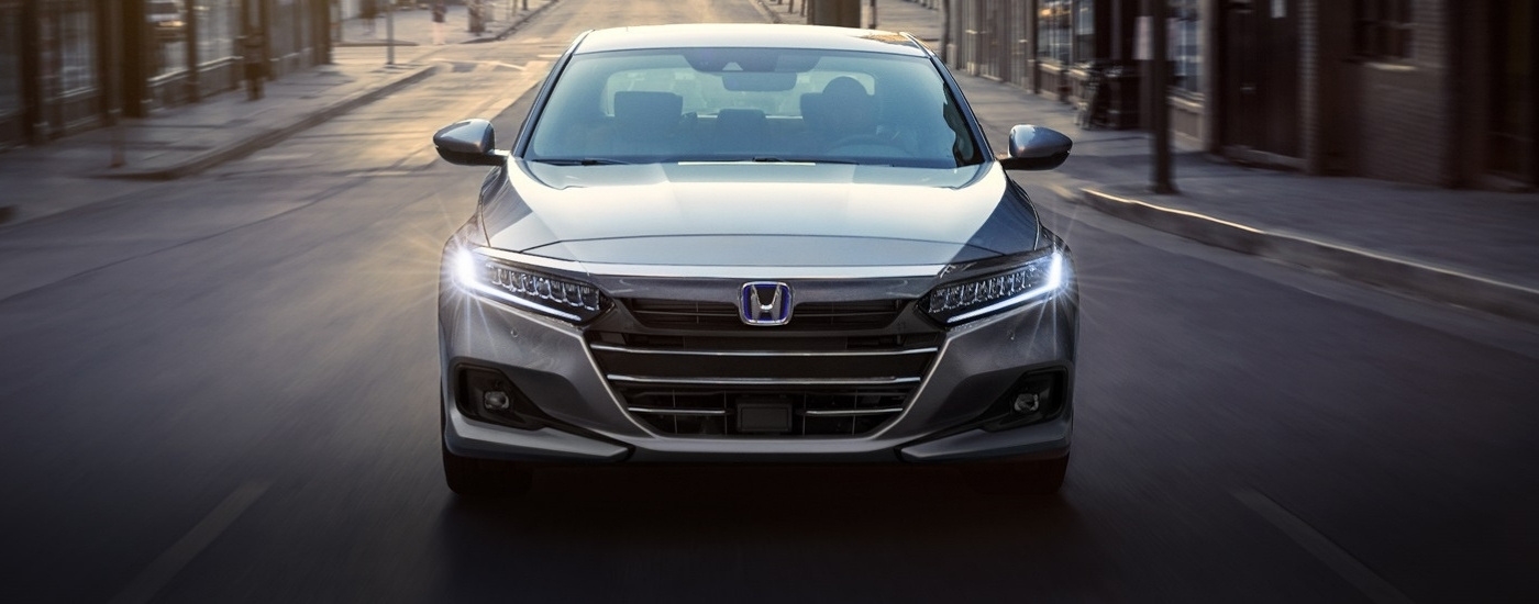 A silver 2022 Honda accord shown driving head on.