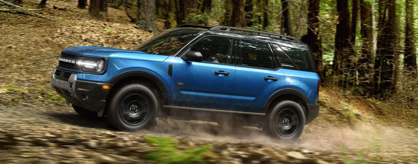 Blue 2026 Ford Bronco Sport driving on an off-road trail.