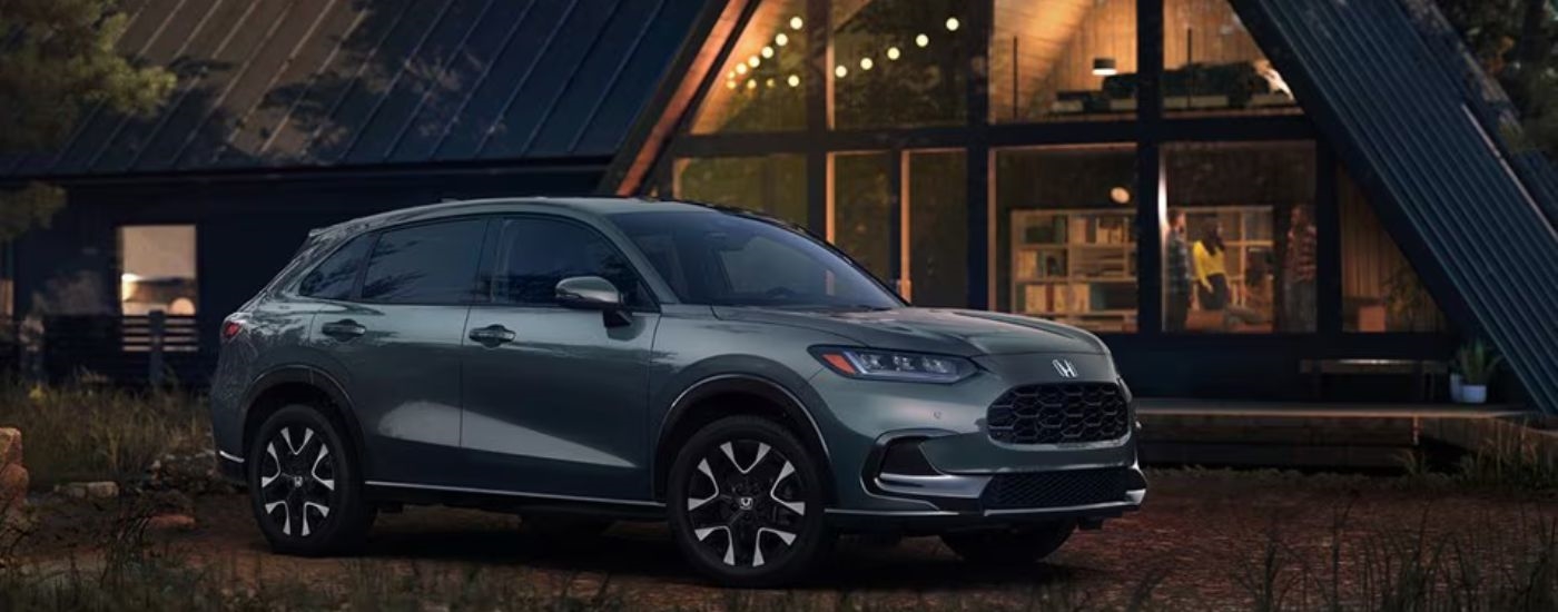 Grey 2026 Honda HR-V parked in front of a cabin.