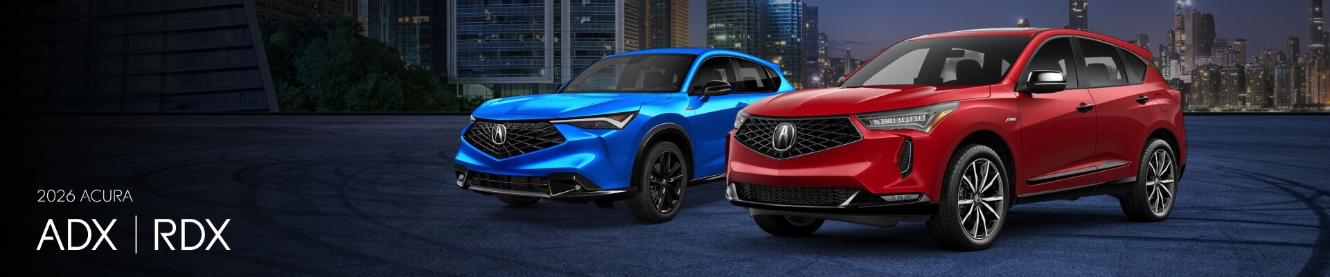 A blue 2026 Acura ADX and a red 2026 Acura RDX parked in a city parking lot at night.
