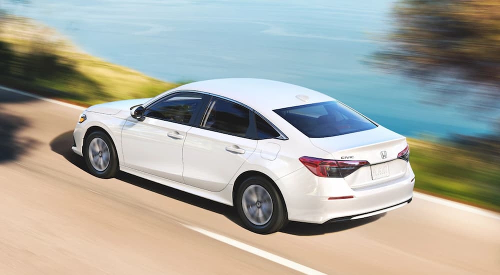 A white 2022 Honda Civic LX driving by the ocean.