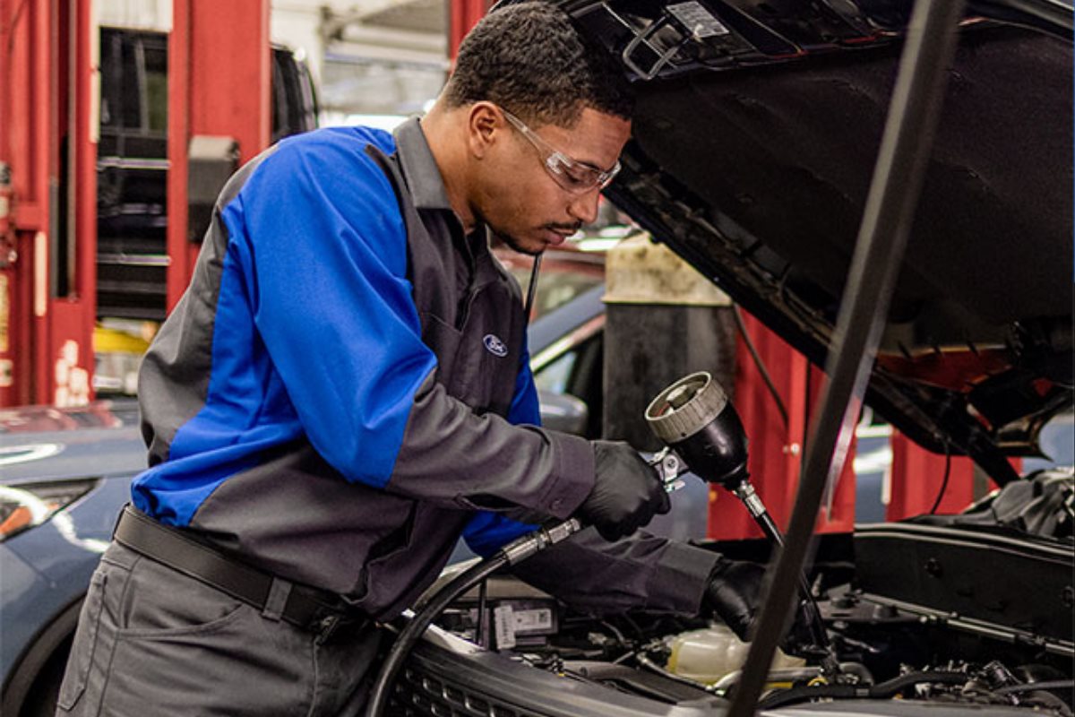 Ford technician performing a vehicle inspection during the Certified Pre-Owned reconditioning process.
