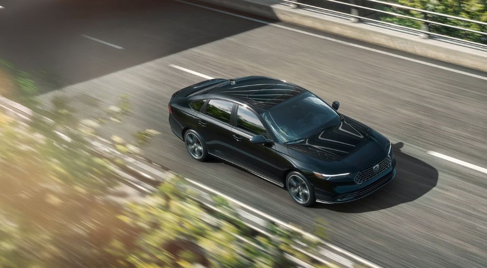 Aerial view of a black 2026 Honda Accord driving on a road.