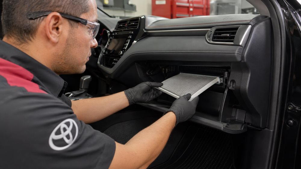 Used cabin air filter beside a clean replacement filter for a Toyota