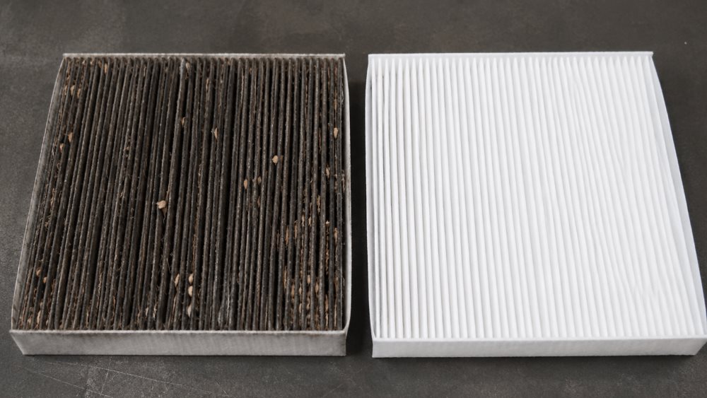 Technician correctly installing a Toyota cabin air filter in its housing