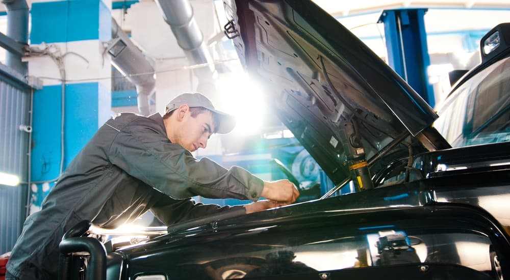 A service technician working on the engine compartment.