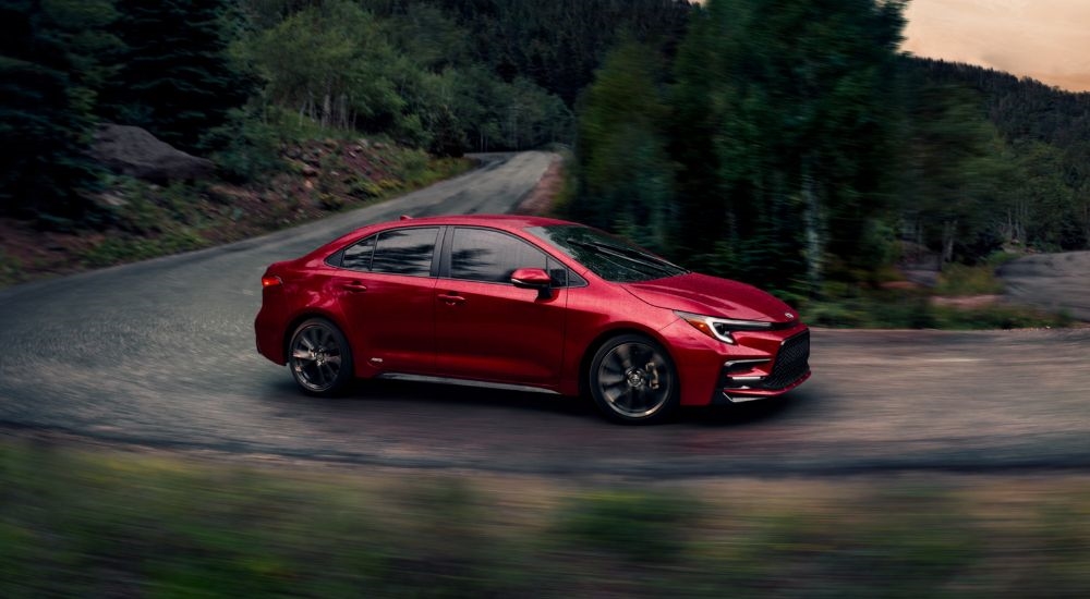 A red 2026 Toyota Corolla AWD driving around a corner.