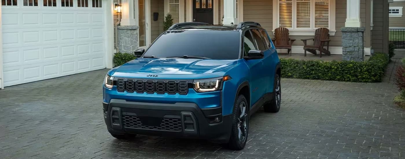 Blue 2026 Jeep Cherokee parked on a driveway.