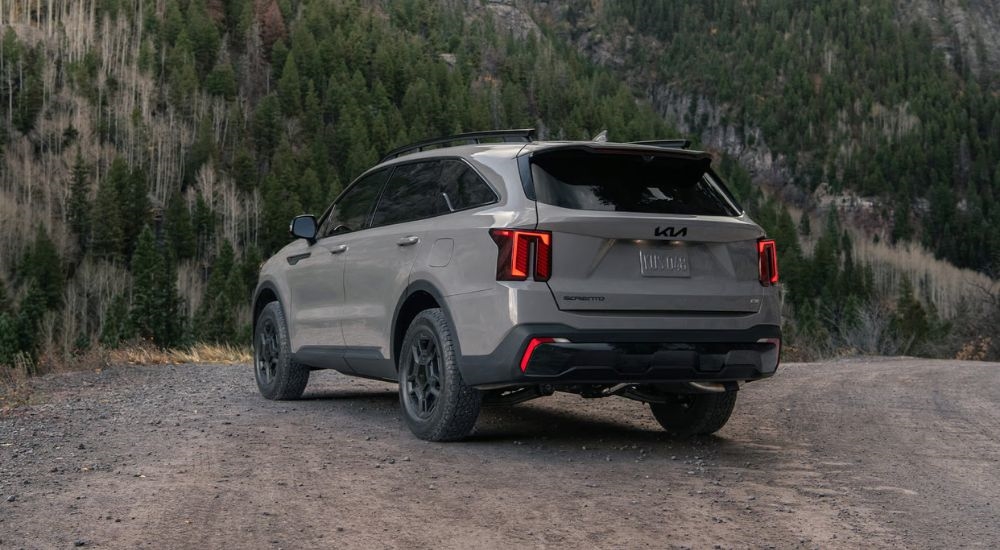 Tan 2026 Kia Sorento rear view parked in the woods.