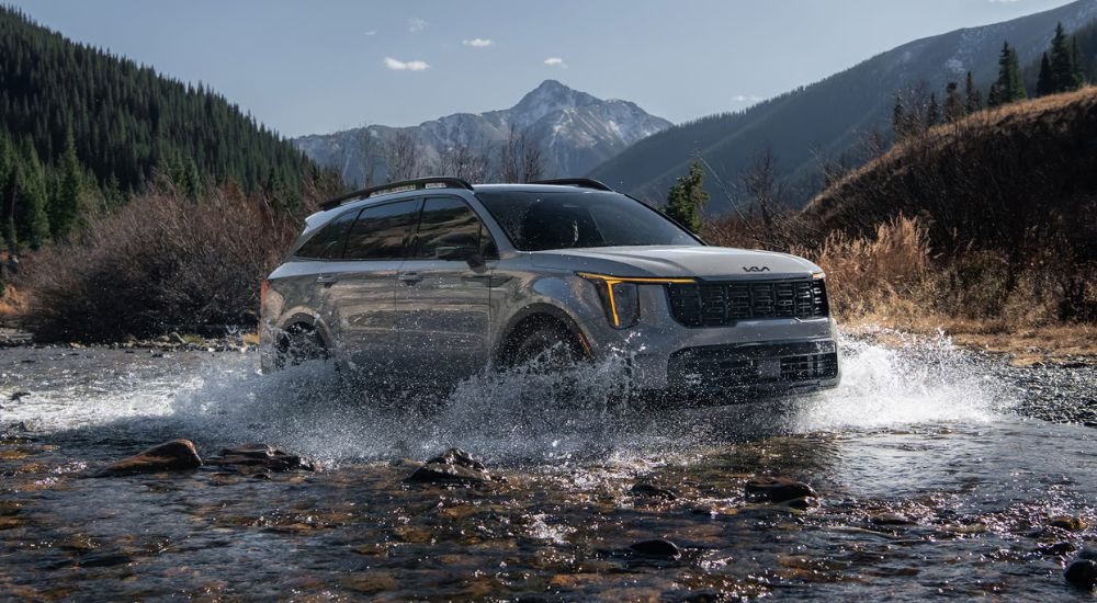 Grey 2026 Kia Sorento driving through a river.
