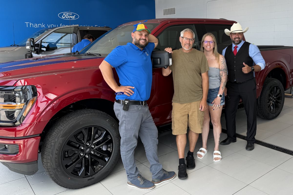 Happy customers posing with their new Ford Explorer and dealership staff at Gordie Boucher Ford of Kenosha.