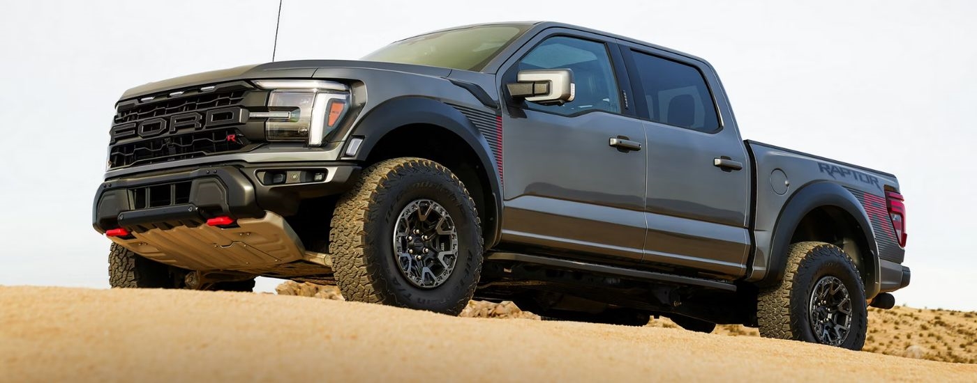 Grey 2026 Ford F-150 Raptor off-road in the sand.