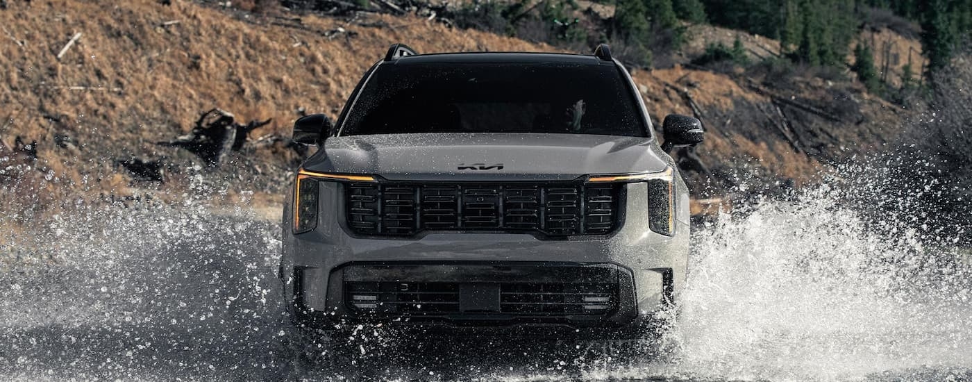 Grey 2026 Kia Sorento fording a shallow river.