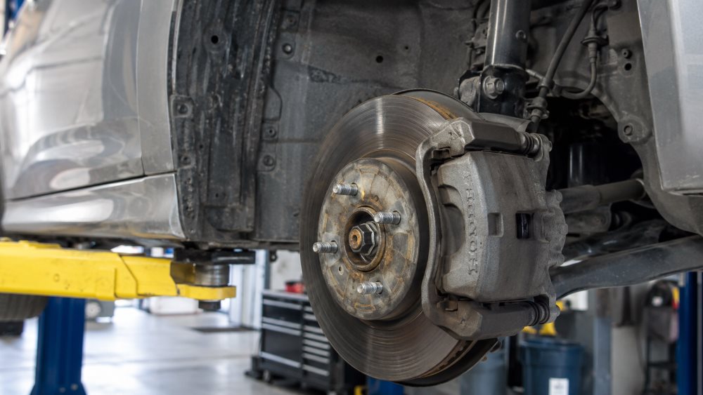 Honda front brake rotor and caliper on a lift during a brake inspection at Honda Libertyville