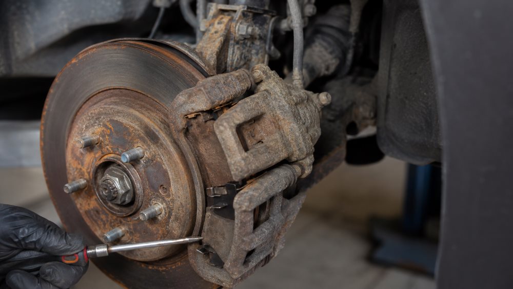 Road salt and corrosion on a Honda brake rotor and caliper after a Lake County winter