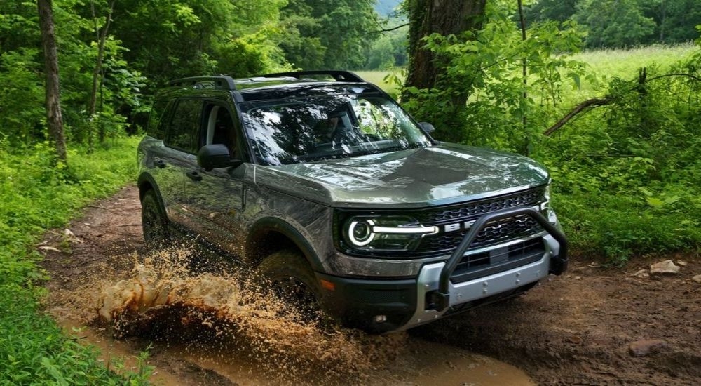 A gray 2026 Ford Bronco Sport driving through mud.